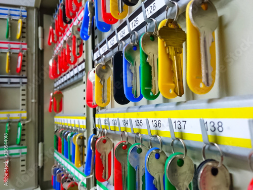 Key box cabinet or locker key for storage with many keychains and track colors hanging inside.