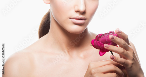 Part of beauty model girl face with fresh skin  pink flower near head  nude make-up. Female health concept
