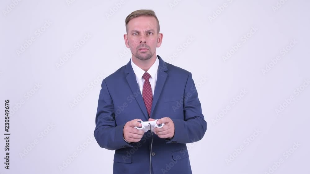 Happy blonde businessman playing games and winning