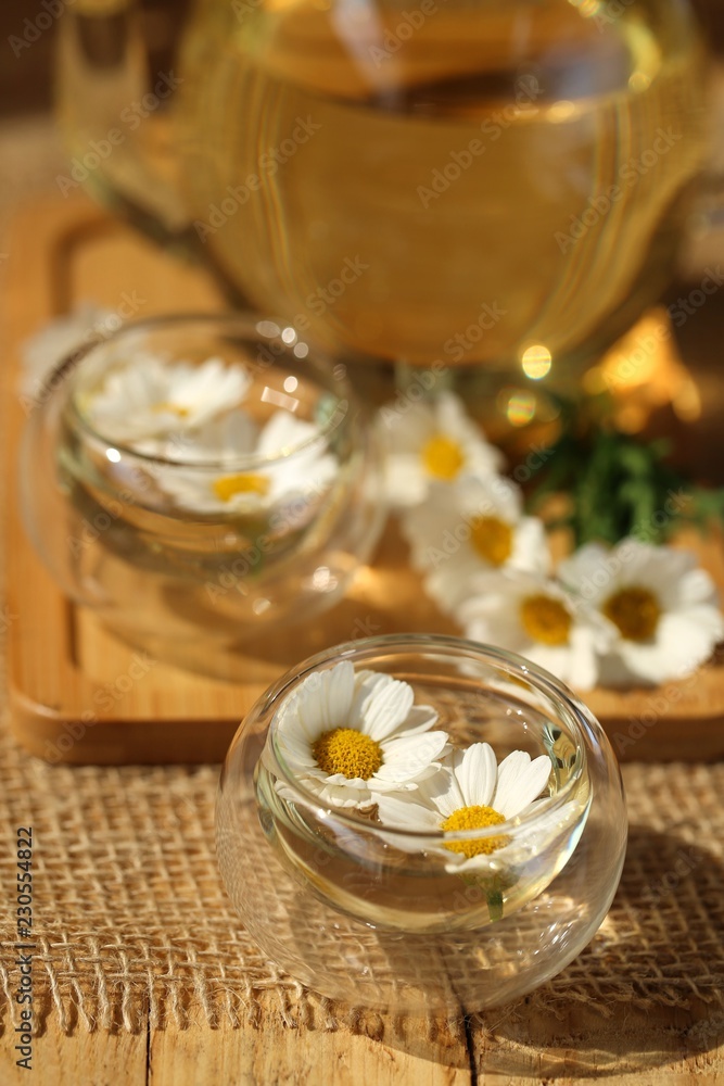 Chamomile tea.Tea in a glass teapots and a clear glass with fresh chamomile on a wooden background.Healing natural herbs.Organic Pure Drink Chamomile tea.Tea in a glass teapots and a clear glass with fresh chamomile on a wooden background.Healing natural herbs.Organic Pure Drink