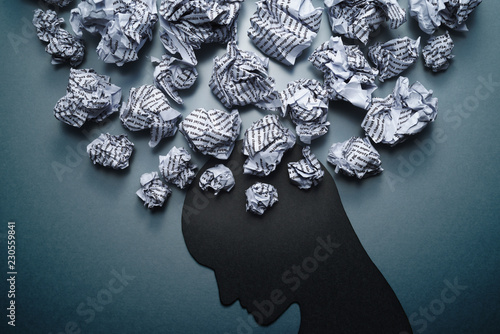 Fototapeta Naklejka Na Ścianę i Meble -  Silhouette of depressed person head. Concept image of depression and anxiety. Waste paper and head silhouette.