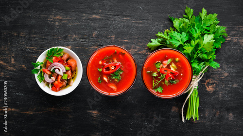 Gazpacho Soup in Glas. Tomato soup with onion, paprika and parsley. Italian cuisine. Top view. On a black background. Free space for text.