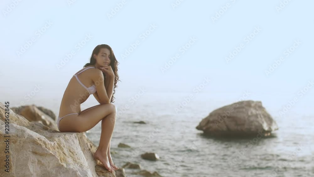 Portrait of beautiful woman on the sea. Romantic sensual brunette mixed race Asian Caucasian woman standing on the beach. Exclusive slow motion 4k footage Portrait of beautiful woman on the sea. Romantic sensual brunette mixed race Asian Caucasian woman standing on the beach. Exclusive slow motion 4k footage