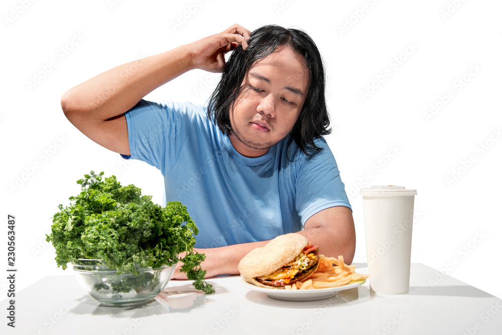 Young asian fat man confused choosing between fast food or healthy food Young asian fat man confused choosing between fast food or healthy food