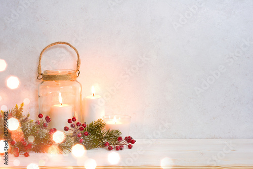 Christmas background, burning lantern candles decorated with frosted fir branches