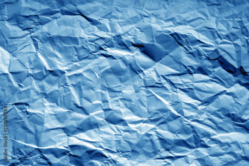 Crumpled sheet of paper with blur effect in navy blue tone.