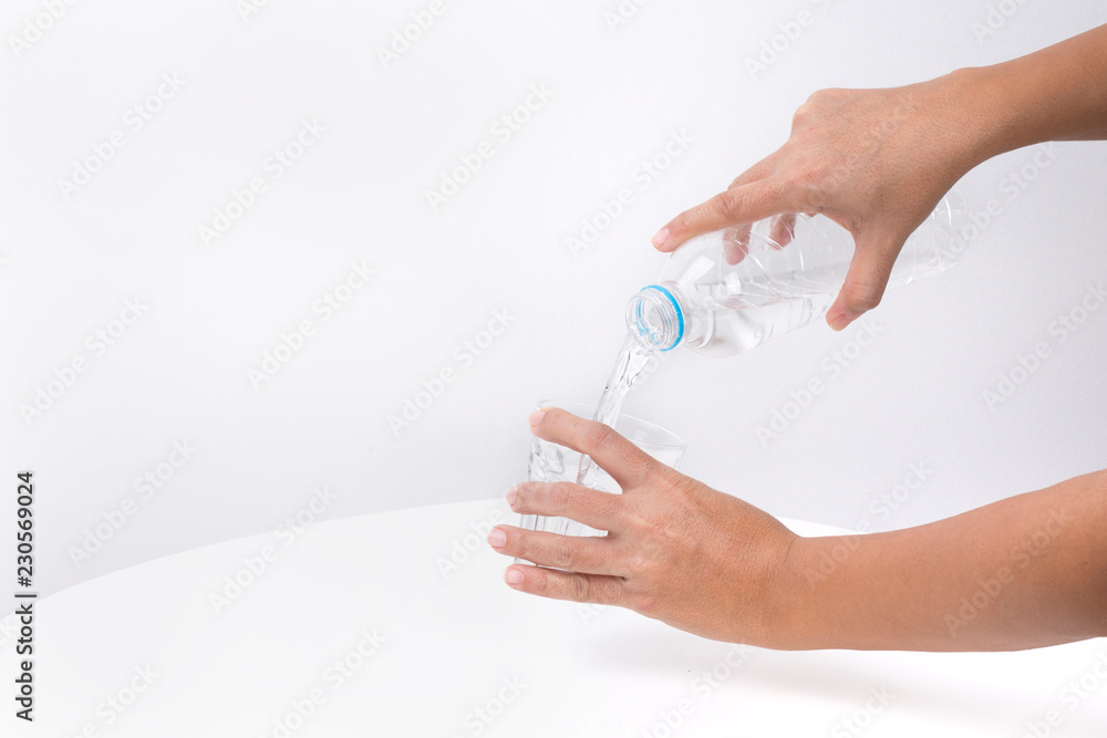 Hand Pouring water from a bottle in to a glass Hand Pouring water from a bottle in to a glass