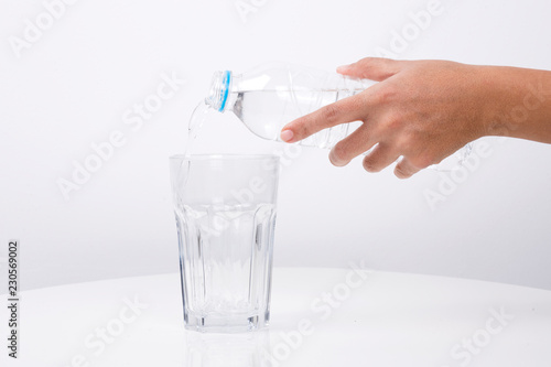 Hand Pouring water from a bottle in to a glass
