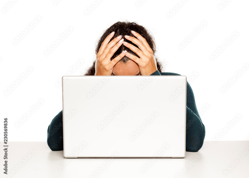 Frustrated young african woman at her laptop on white background Frustrated young african woman at her laptop on white background
