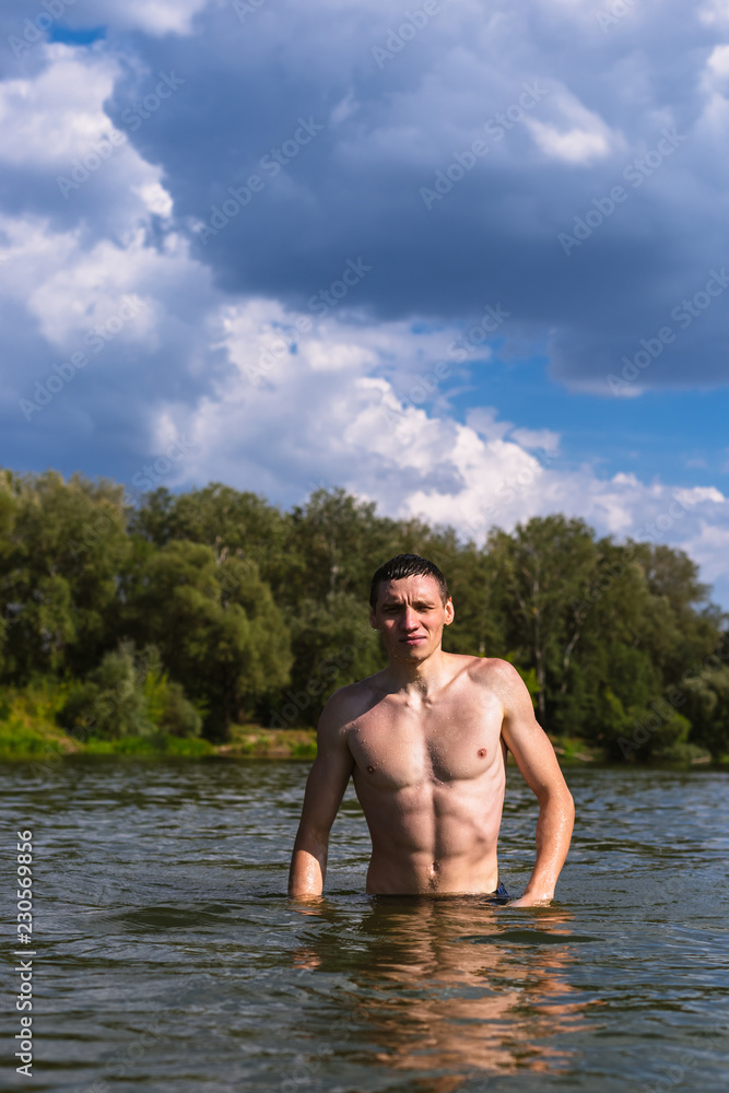 Fototapeta premium Portrait of a handsome young man in the water.