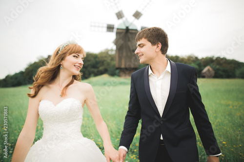 Emotional beautiful bride hugging newlywed groom at a field closeup