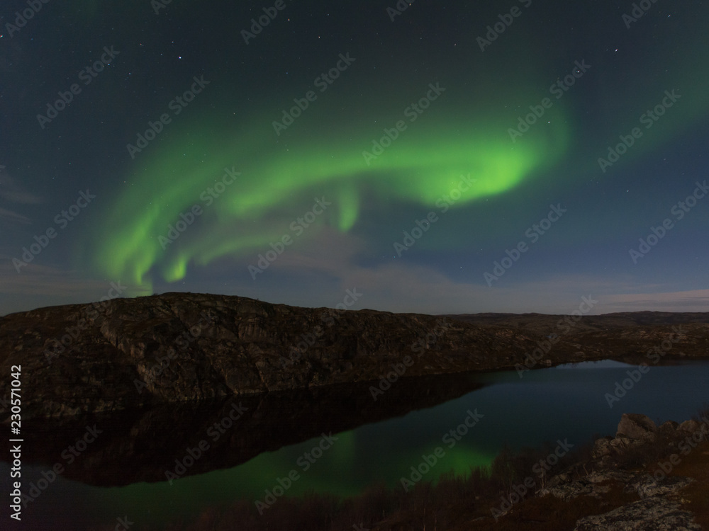 Northern lights, aurora in autumn over the lake.