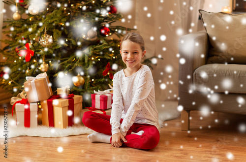 christmas, holidays and childhood concept - smiling girl at home