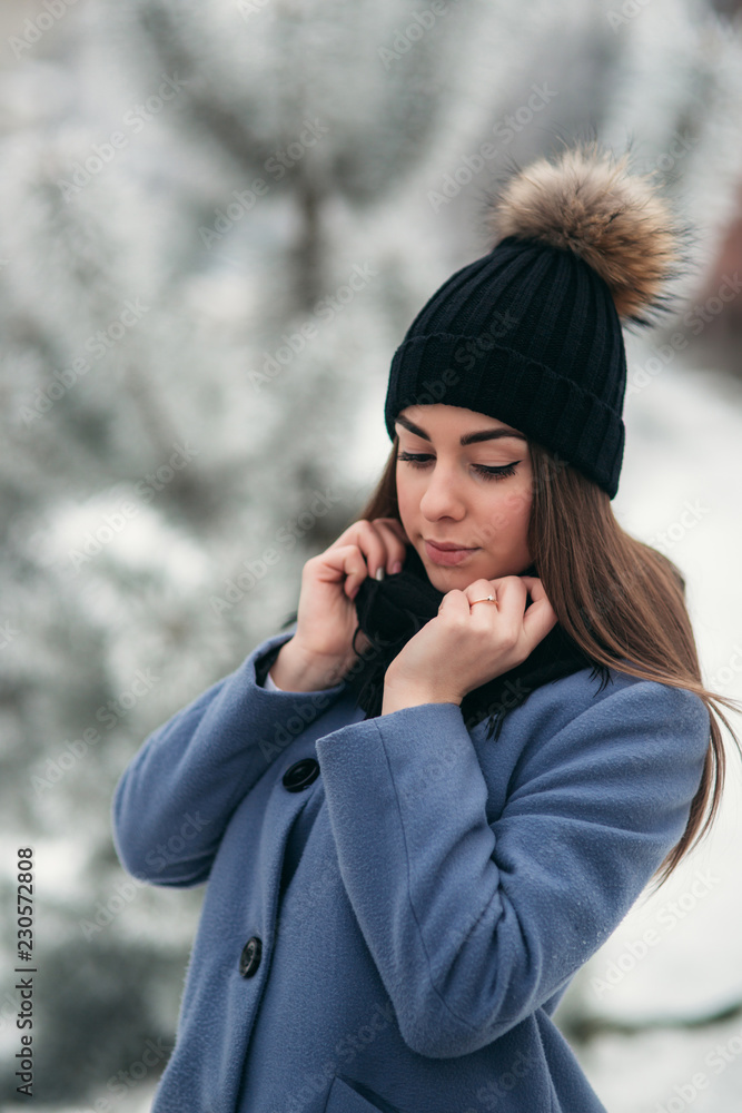 Beautiful winter portrait of young woman in the winter snowy scenery Beautiful winter portrait of young woman in the winter snowy scenery