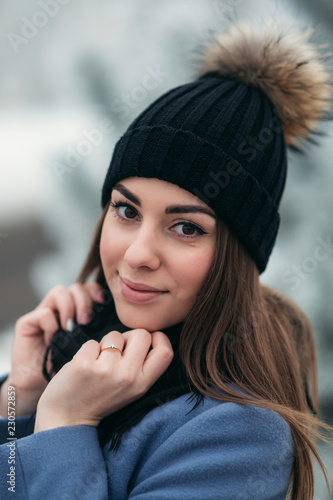 Beautiful winter portrait of young woman in the winter snowy scenery