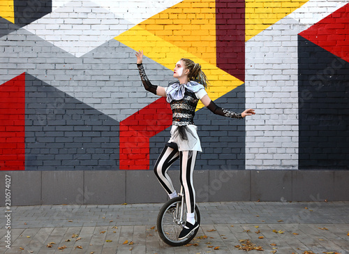 Girl clown performing with a unicycle photo