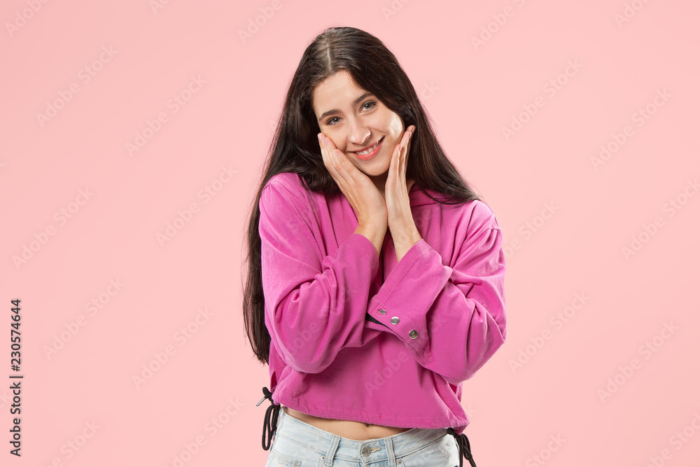 Happy business woman standing and smiling isolated on pink studio background. Beautiful female half-length portrait. Young emotional woman. The human emotions, facial expression concept