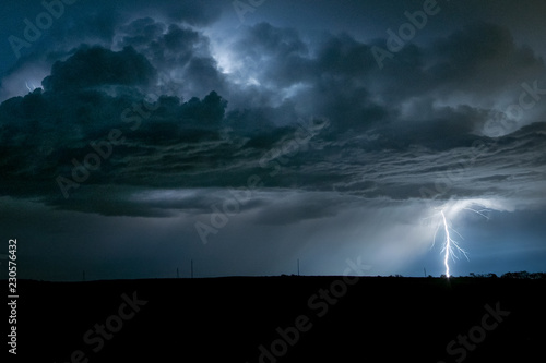 A powerful branched lightningbolt strikes down from a severe thunderstorm in Nebraska