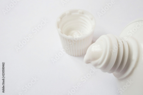 open the tube of toothpaste against white background