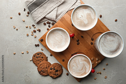 Cups with tasty aromatic coffee and cookies on grey table