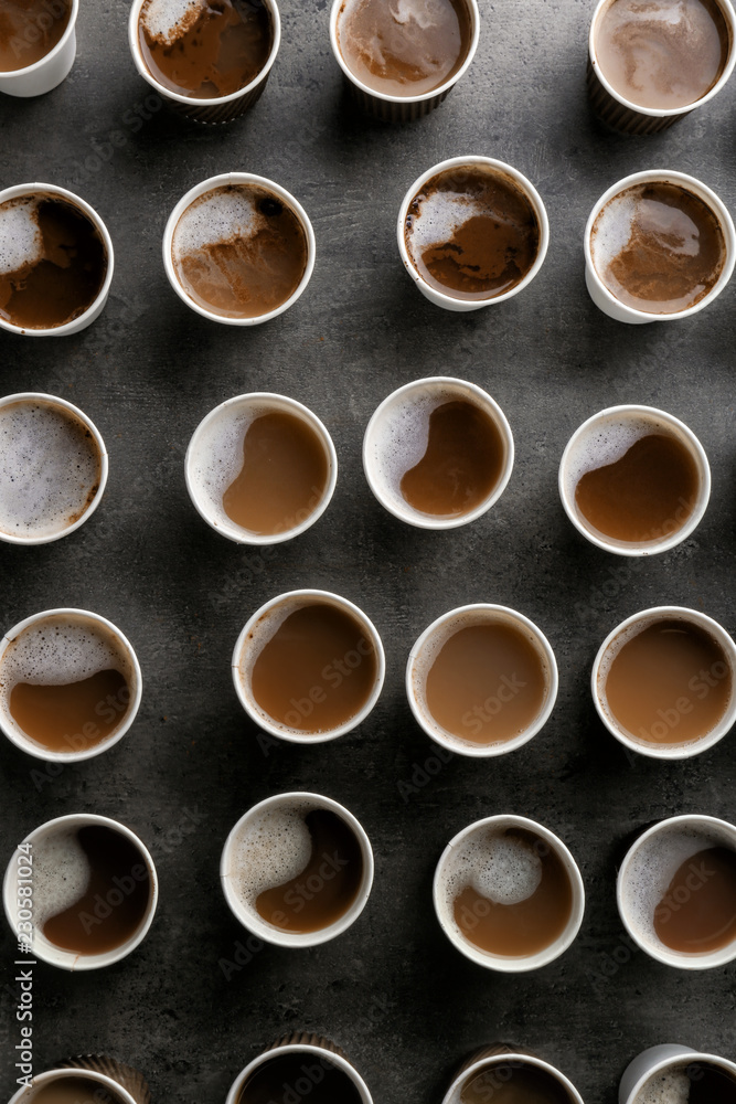 Many plastic cups with tasty aromatic coffee on dark background, flat lay Many plastic cups with tasty aromatic coffee on dark background, flat lay
