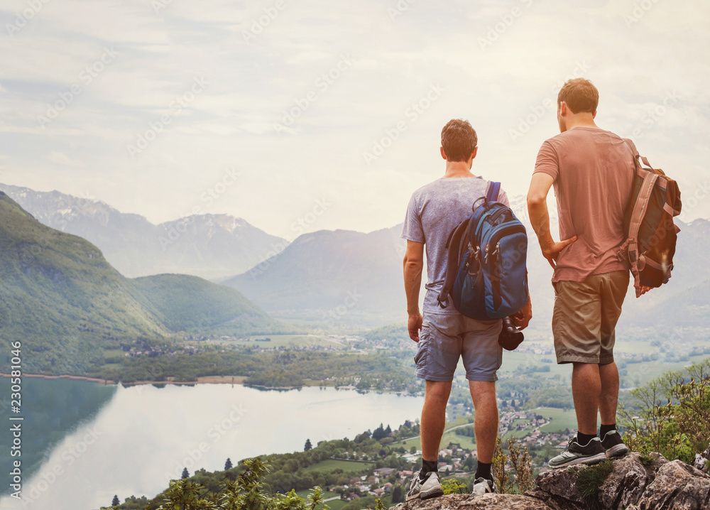 travel people, hikers standing on top of mountain and relaxing with backpacks