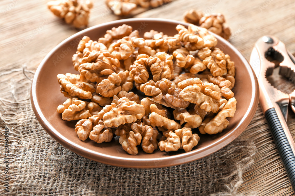 Plate with tasty walnuts on table Plate with tasty walnuts on table