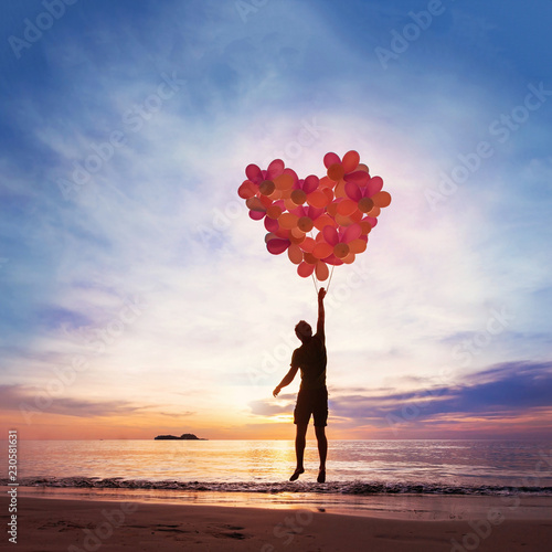 Kindness and love concept, child flying with heart from balloons.