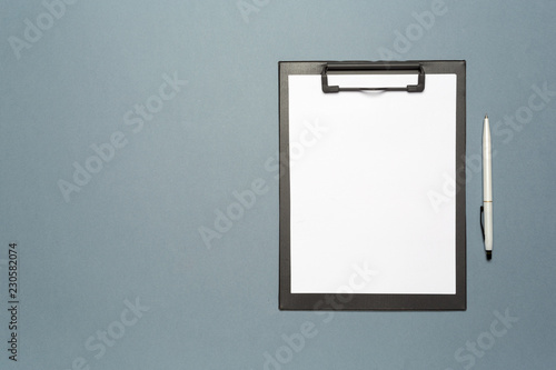Notes clipboard with pen and blank sheets of paper as mock up copy space, top view