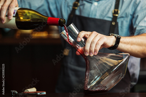Принти на полотні Sommelier pouring red wine into carafe to make perfect color