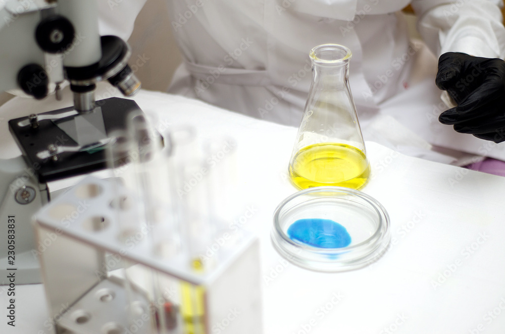 laboratory worker in a white coat working with chemicals under a microscope laboratory worker in a white coat working with chemicals under a microscope