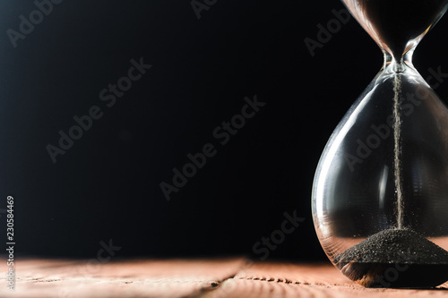 Modern hourglass on wooden background photo