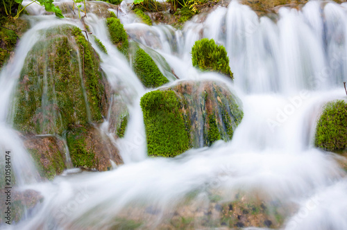Silky waterfall streams surrounded by mossy rocks and forest plants in Plitvice Lakes National Park  Croatia