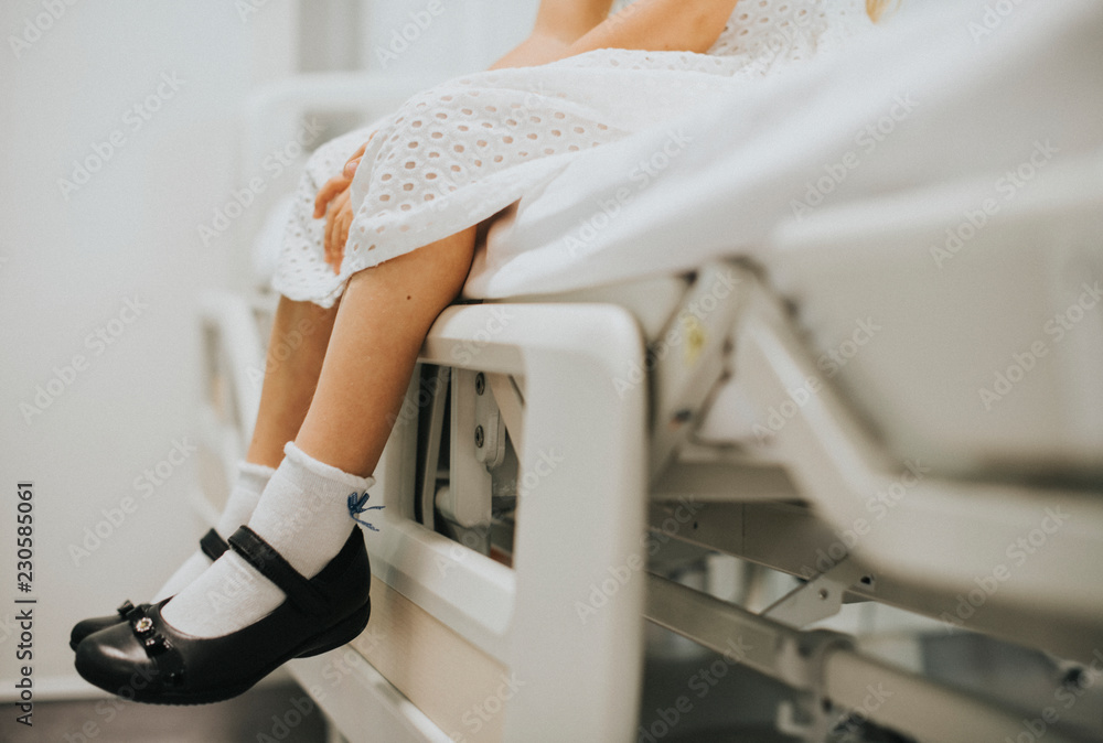 Young girl sitting on a hospital bed Young girl sitting on a hospital bed
