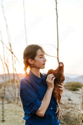 Young woman with a brown hen