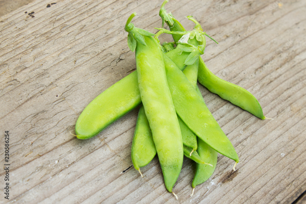 Pods of green peas on the background of old wood. The concept of vegetarianism and healthy eating. Copy space. Pods of green peas on the background of old wood. The concept of vegetarianism and healthy eating. Copy space.