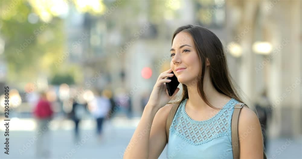 Happy beautiful woman talking on phone standing in the street Happy beautiful woman talking on phone standing in the street