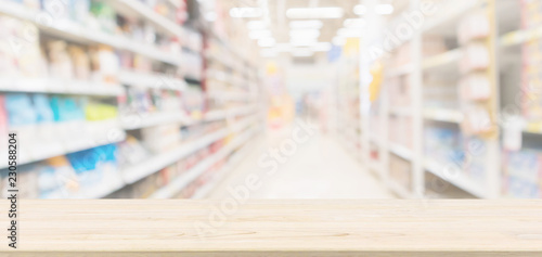 Wood table top with supermarket aisle blur background for product display © Piman Khrutmuang