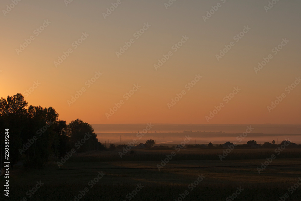 Early autumn morning in Eastern Europe. The red dawn covered the misty valleys.