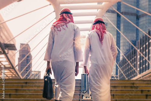 Photography Two business people with briefcase walking together in teamwork,  Saudi Arabian business concept