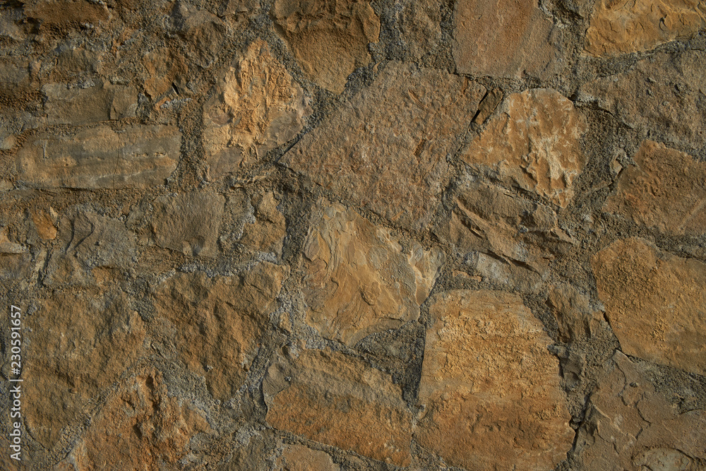 Texture background old stone wall. Wall texture of ancient old brick stone. Outdoor exterior castle facade with destroyed uneven pattern of shabby rock. Texture background old stone wall. Wall texture of ancient old brick stone. Outdoor exterior castle facade with destroyed uneven pattern of shabby rock.