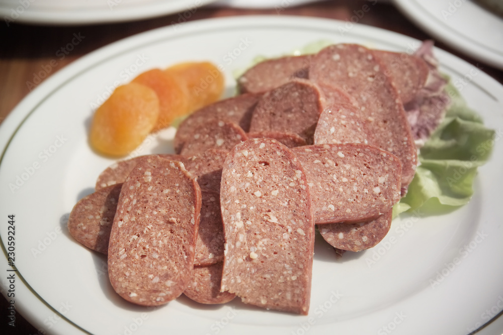 close up shot of sliced pepperoni plate on breakfast table