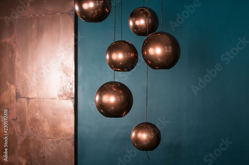 Sphere bronze lamps with turquoise backdrop. Beautiful reflections. Modern interior in blue and brown colors. Christmas and New Year decoration concept. Empty space for your test and design