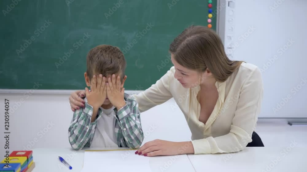 kind teacher calms crying scholar boy during extracurricular activities ...