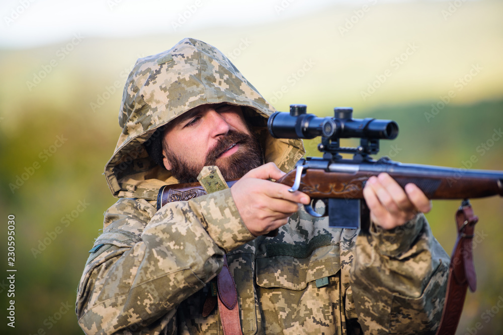 Fototapeta premium Guy hunting nature environment. Bearded hunter rifle nature background. Experience and practice lends success hunting. Hunting big game typically requires tag each animal harvested. Hunting season