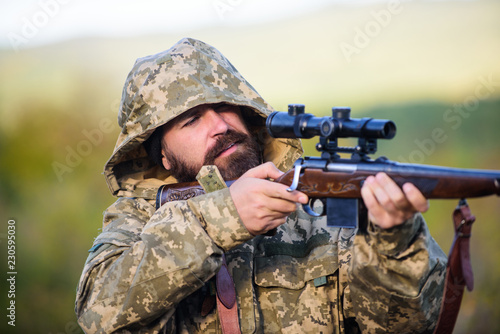 Guy hunting nature environment. Bearded hunter rifle nature background. Experience and practice lends success hunting. Hunting big game typically requires tag each animal harvested. Hunting season