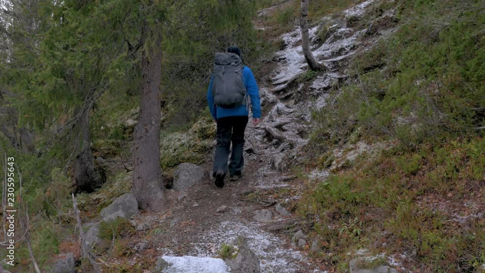 Traveler with a backpack climbs up the mountain path. He explores new routes for himself. Active travel and healthy life. Traveler with a backpack climbs up the mountain path. He explores new routes for himself. Active travel and healthy life.