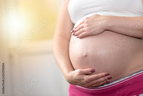 Pregnant woman with hands on her belly © thodonal