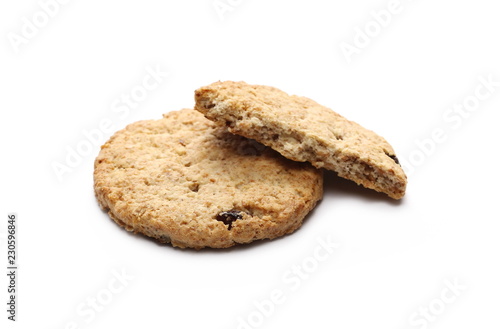 Round cracked wholewheat biscuit, cookie with raisins and crumbs isolated on white background