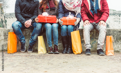 Group of friends sitting outdoor with shopping bags